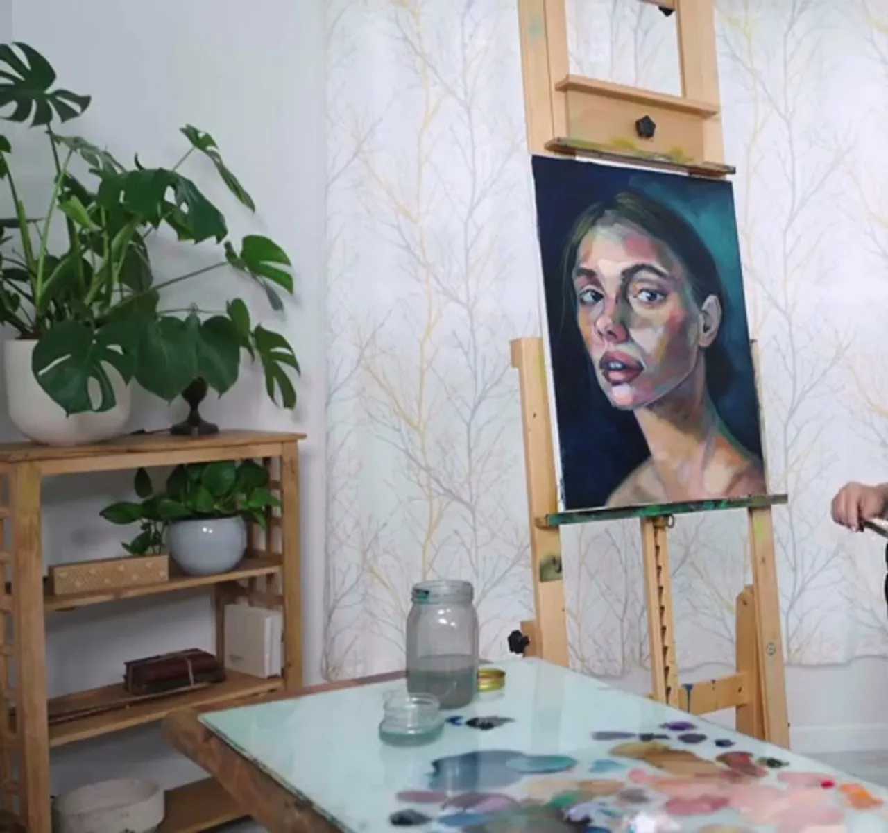 A realistic portrait painting on the easel showing mixed flesh tones