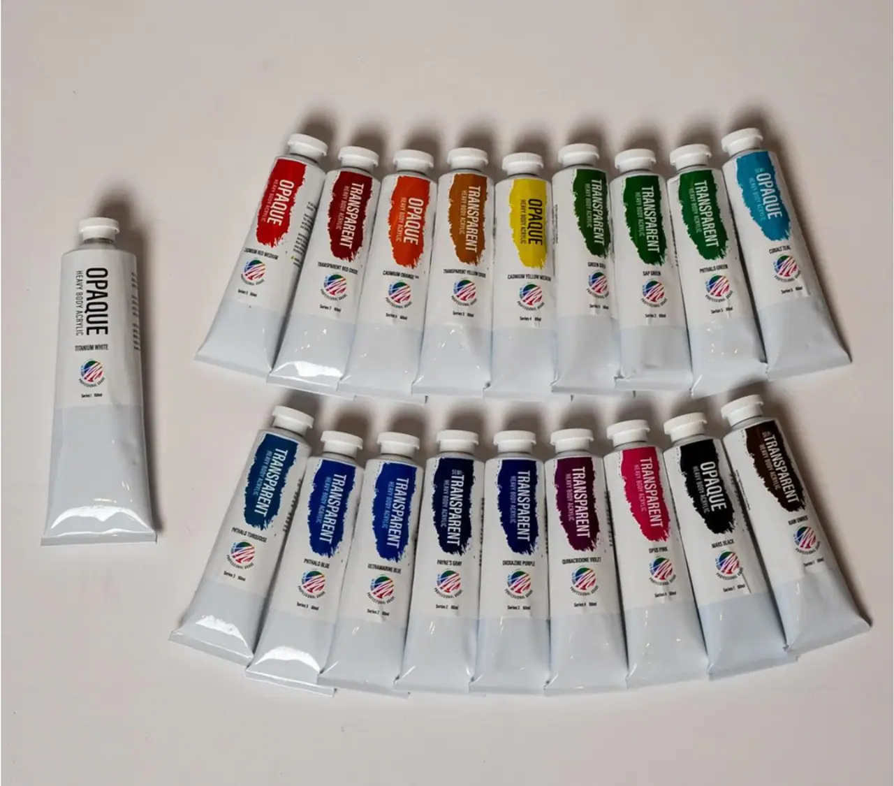 Tubes of professional acrylic paint arranged in a rainbow of colors