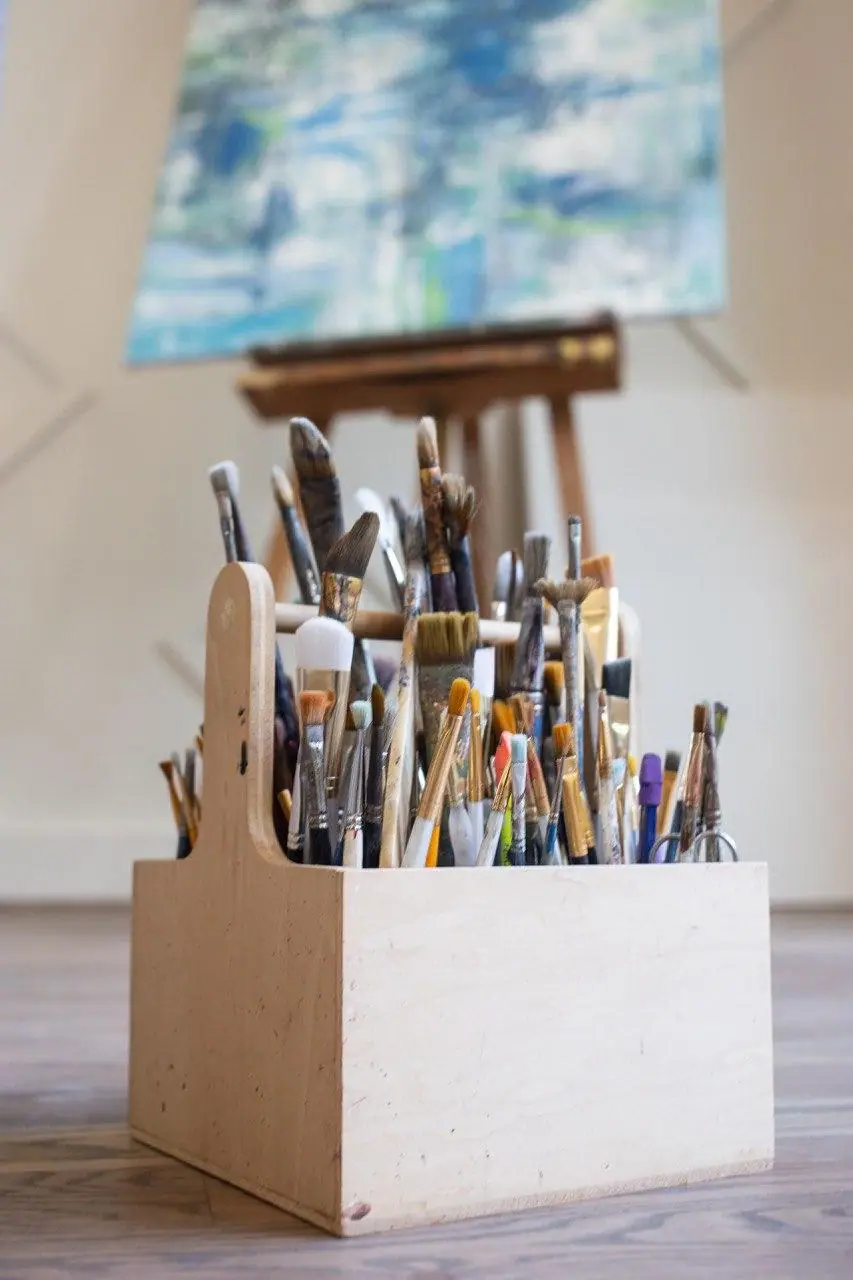 A container holding several clean paintbrushes ready for varnishing