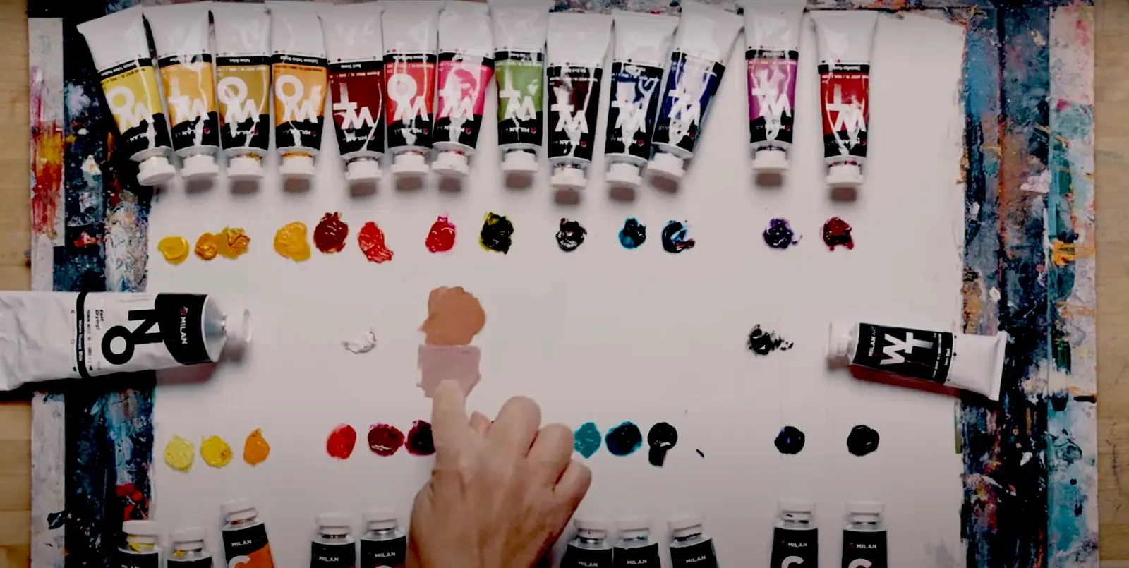 Mixing colors on a palette to show how two pigments blend into a third