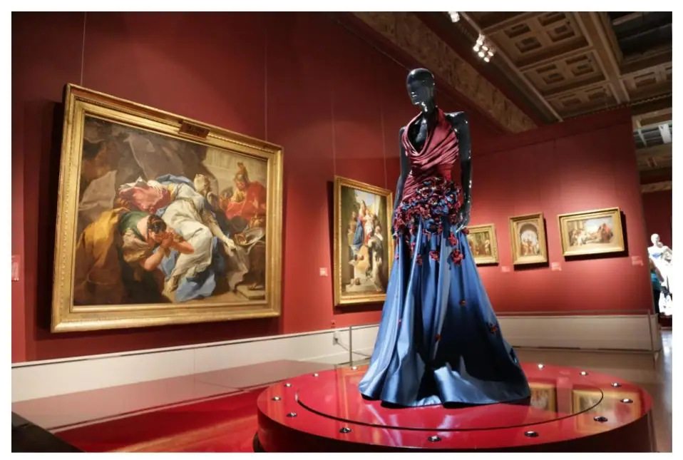 Open book of art reproductions beside a stack of paintings illustrating the study of art history