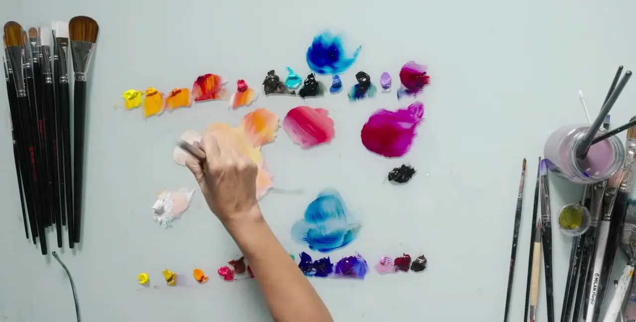 A loaded painting palette with colors laid out in mixing order from warm to cool