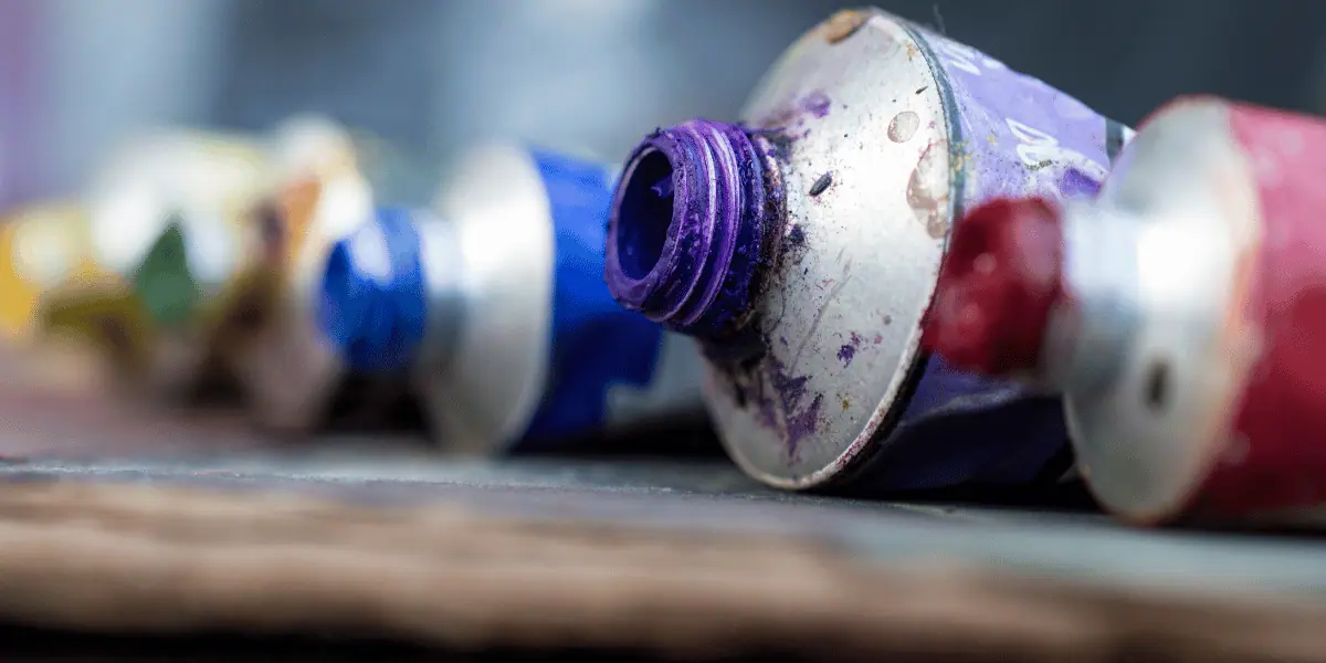 Tubes of acrylic paint in purple, blue, and red