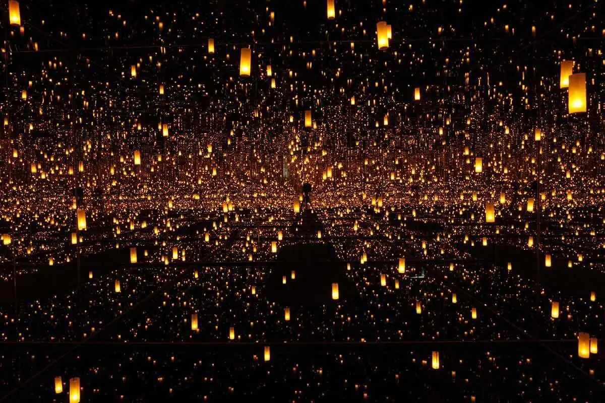 Yayoi Kusama Infinity Mirror Room with mirrored walls and repeating points of light receding into endless reflection