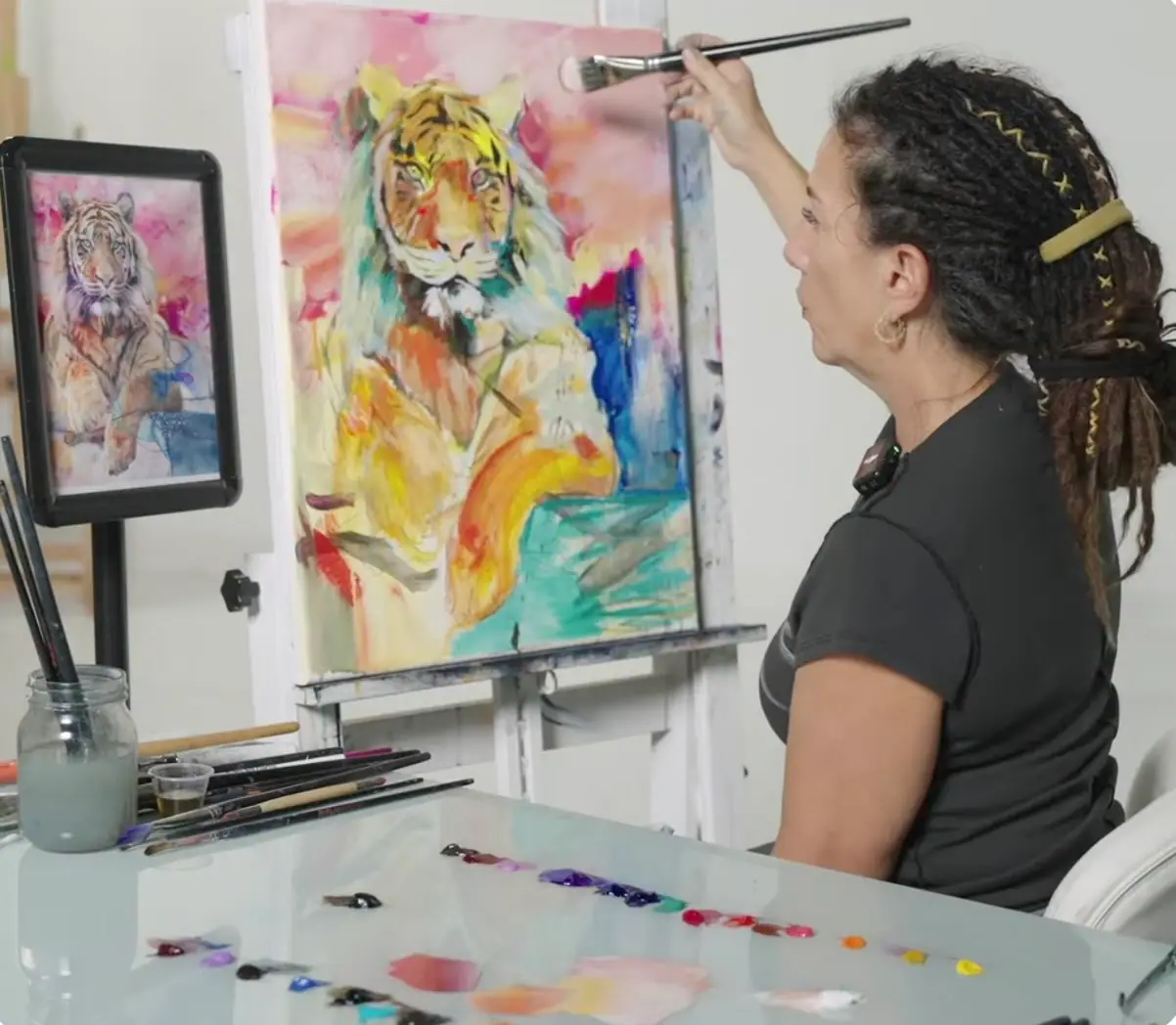 Artist painting a tiger on canvas in yellow, blue, and teal, working soft and sharp edges