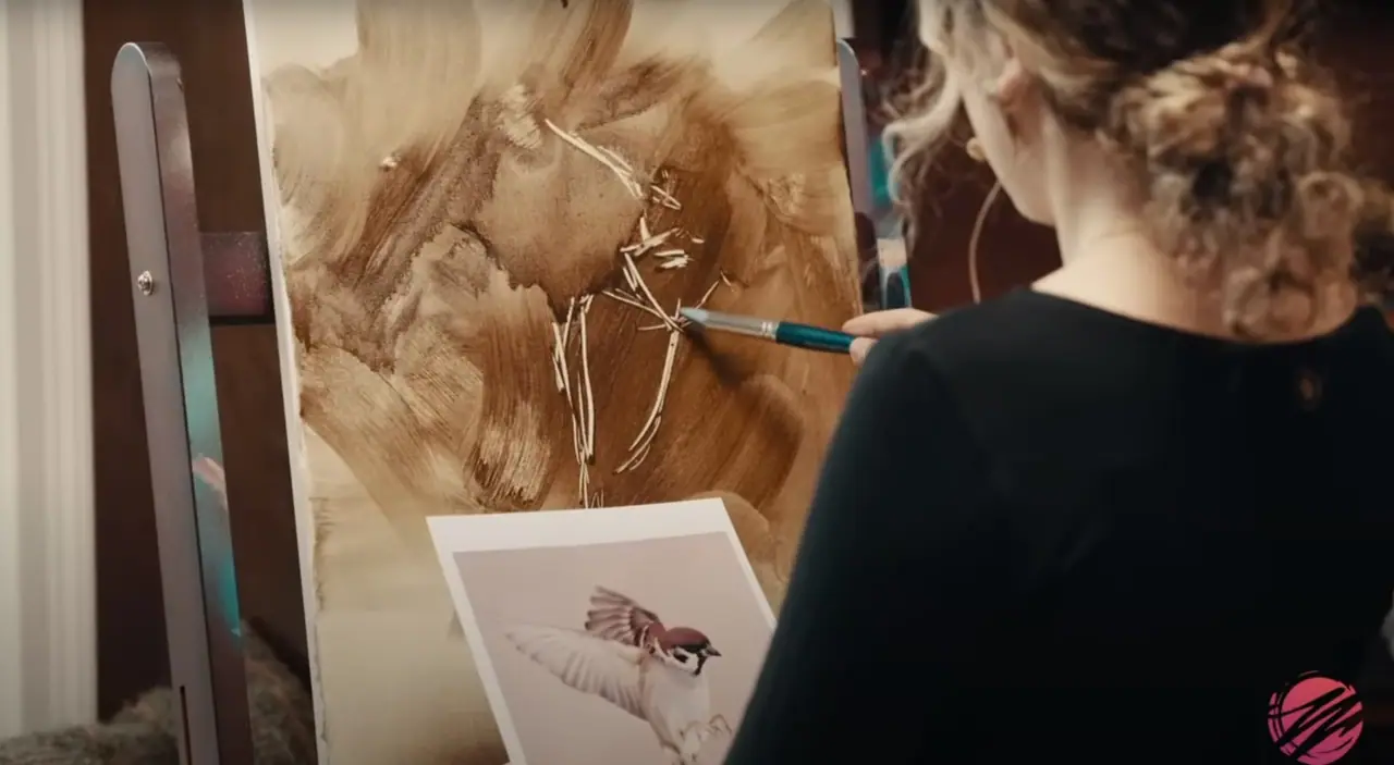 Artist subtracting brown paint to carve out the form of a bird
