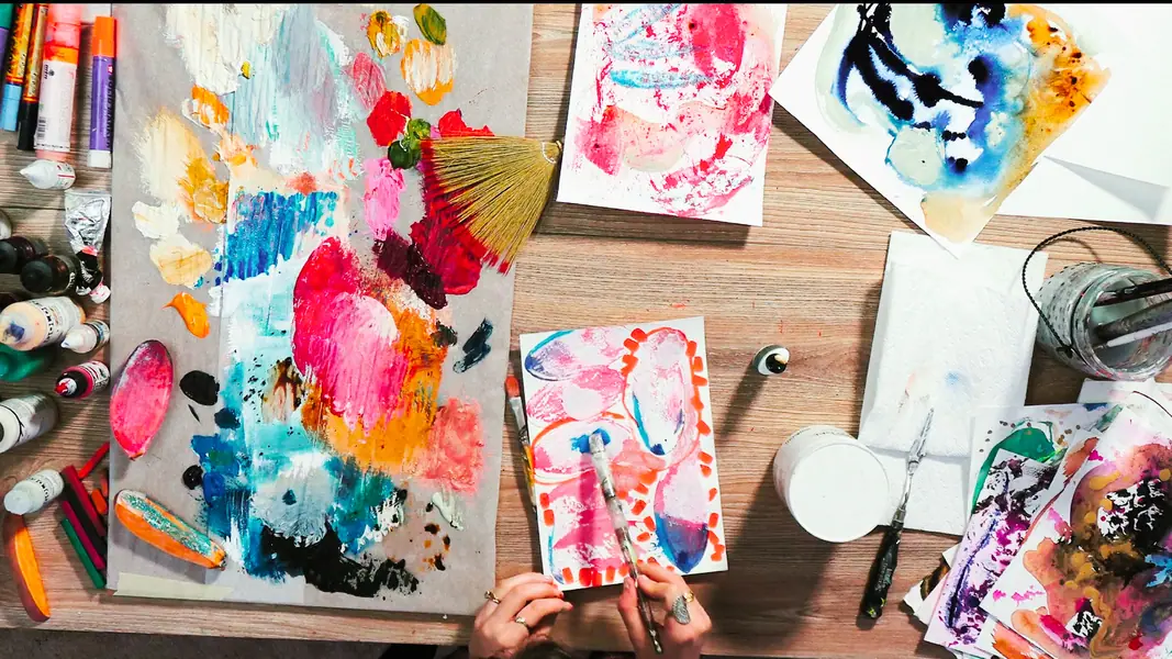 Overhead view of a palette with blue, red, white, and yellow acrylic paint