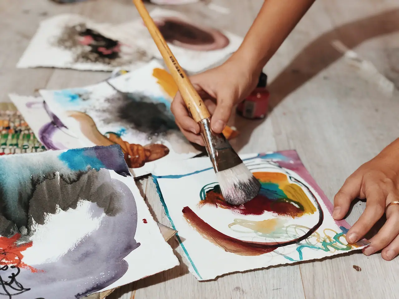Hand painting warm and cool color blocks on paper with a brush