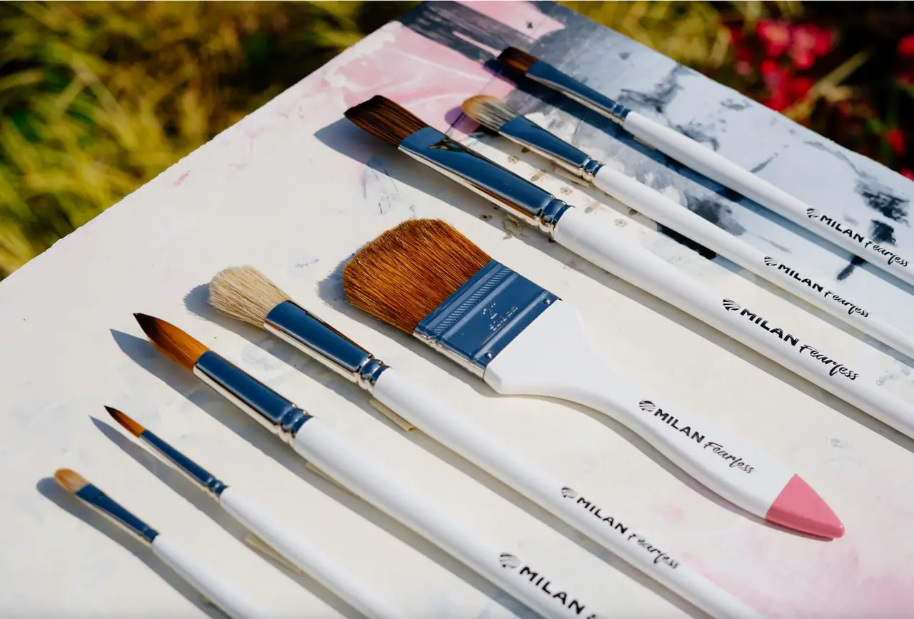Set of oil paint brushes with white handles and natural brown and tan bristles