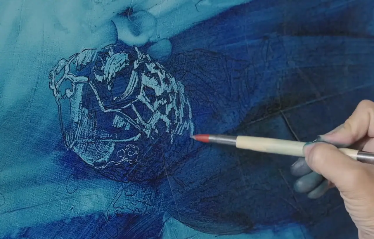 Hand using a subtraction tool to lift highlights from a blue oil layer