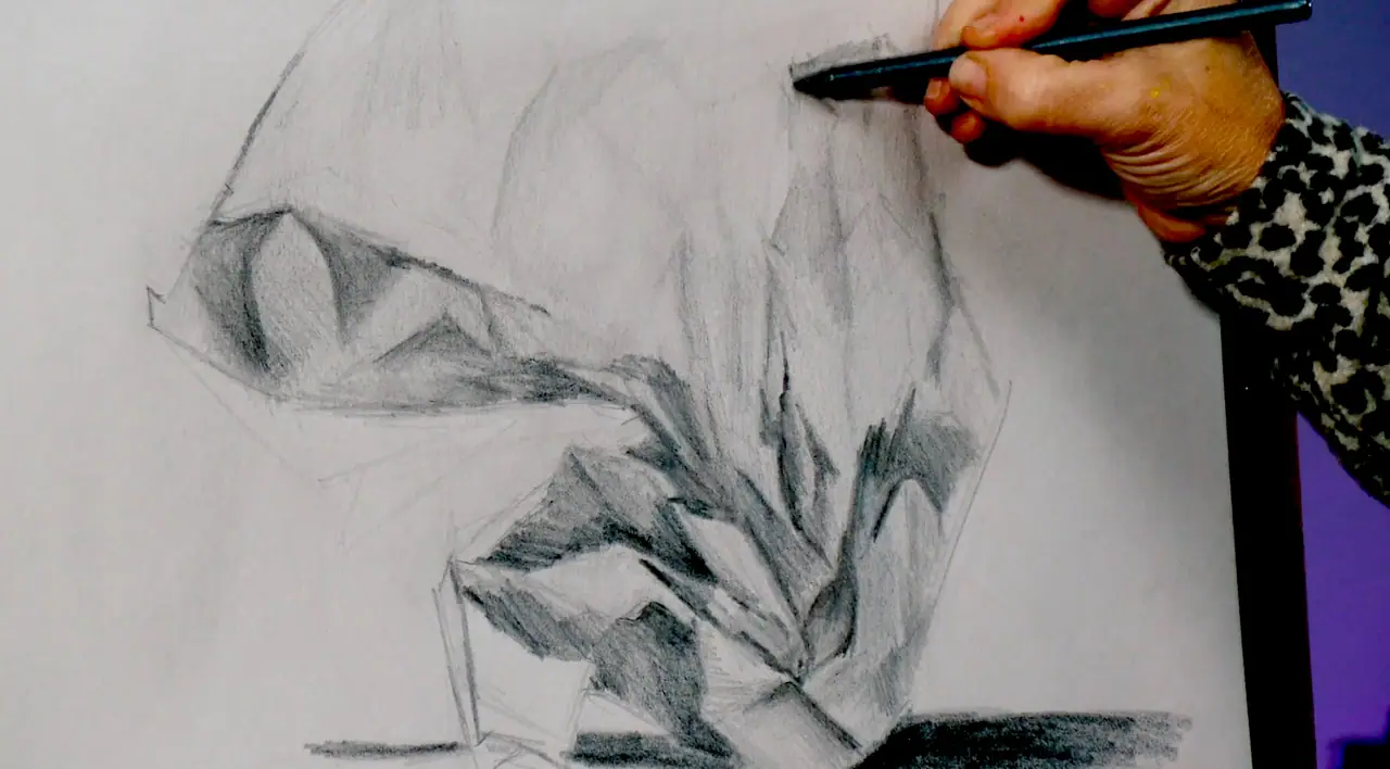 Hand shading a graphite drawing on paper clipped to a board