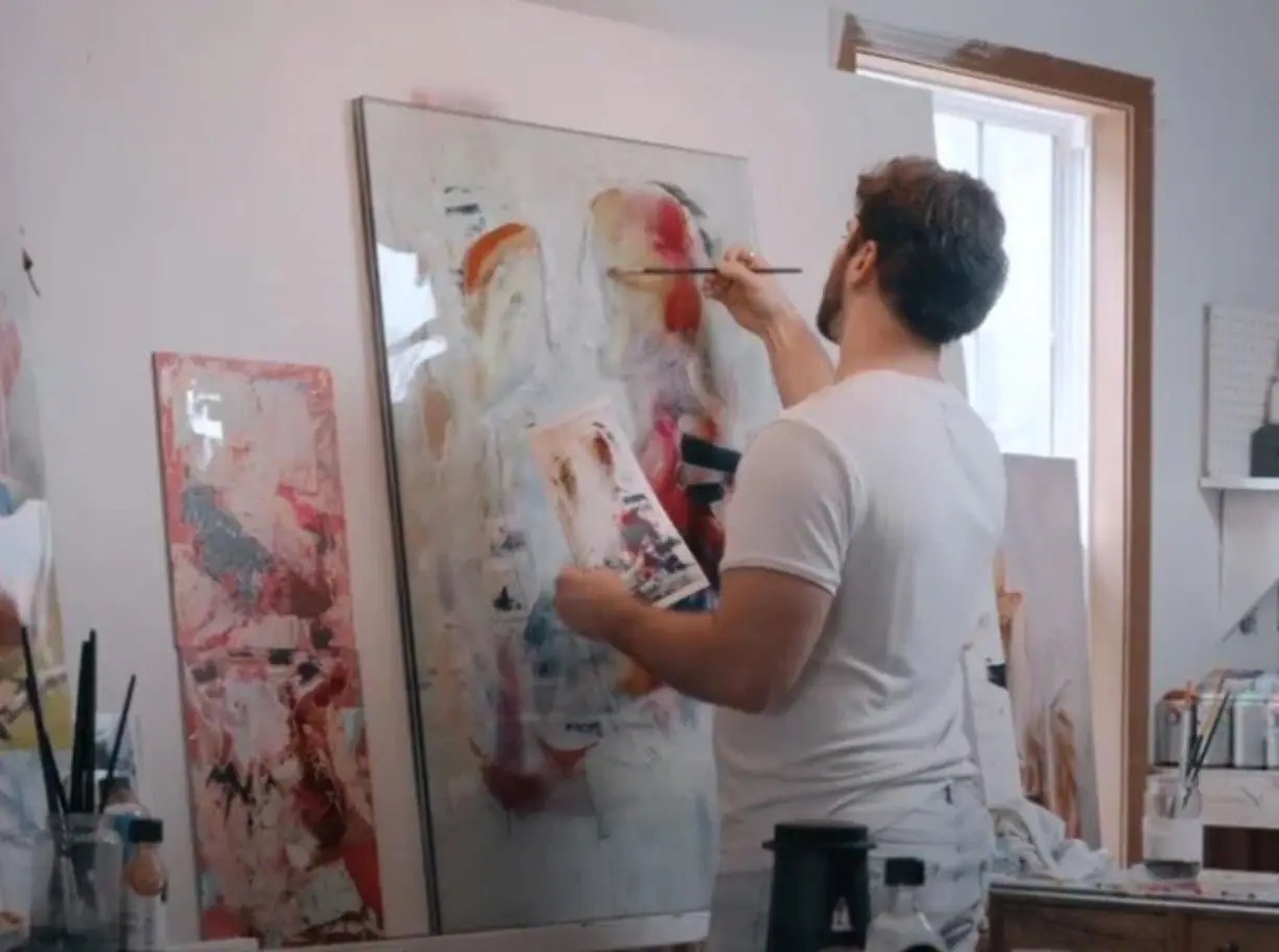 Artist working on a painting while wearing white clothes