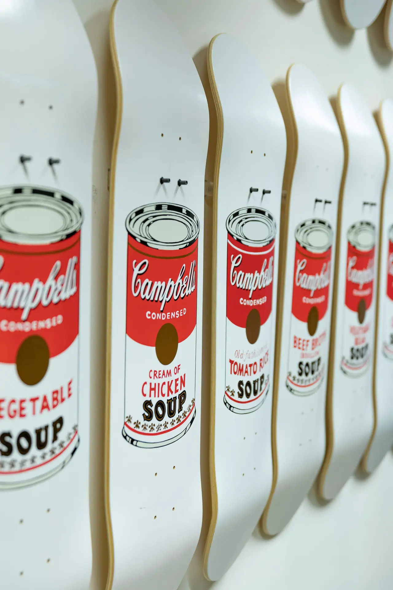 White skateboard decks painted with Campbell's soup can pop art labels