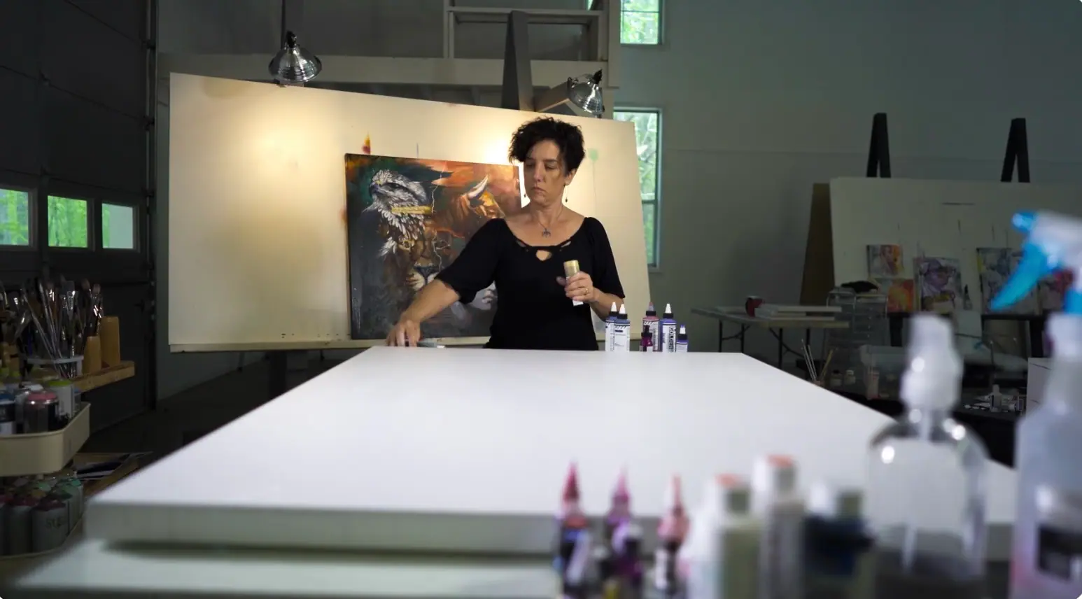 Artist working at an easel in a home studio lit by soft daylight from a nearby window