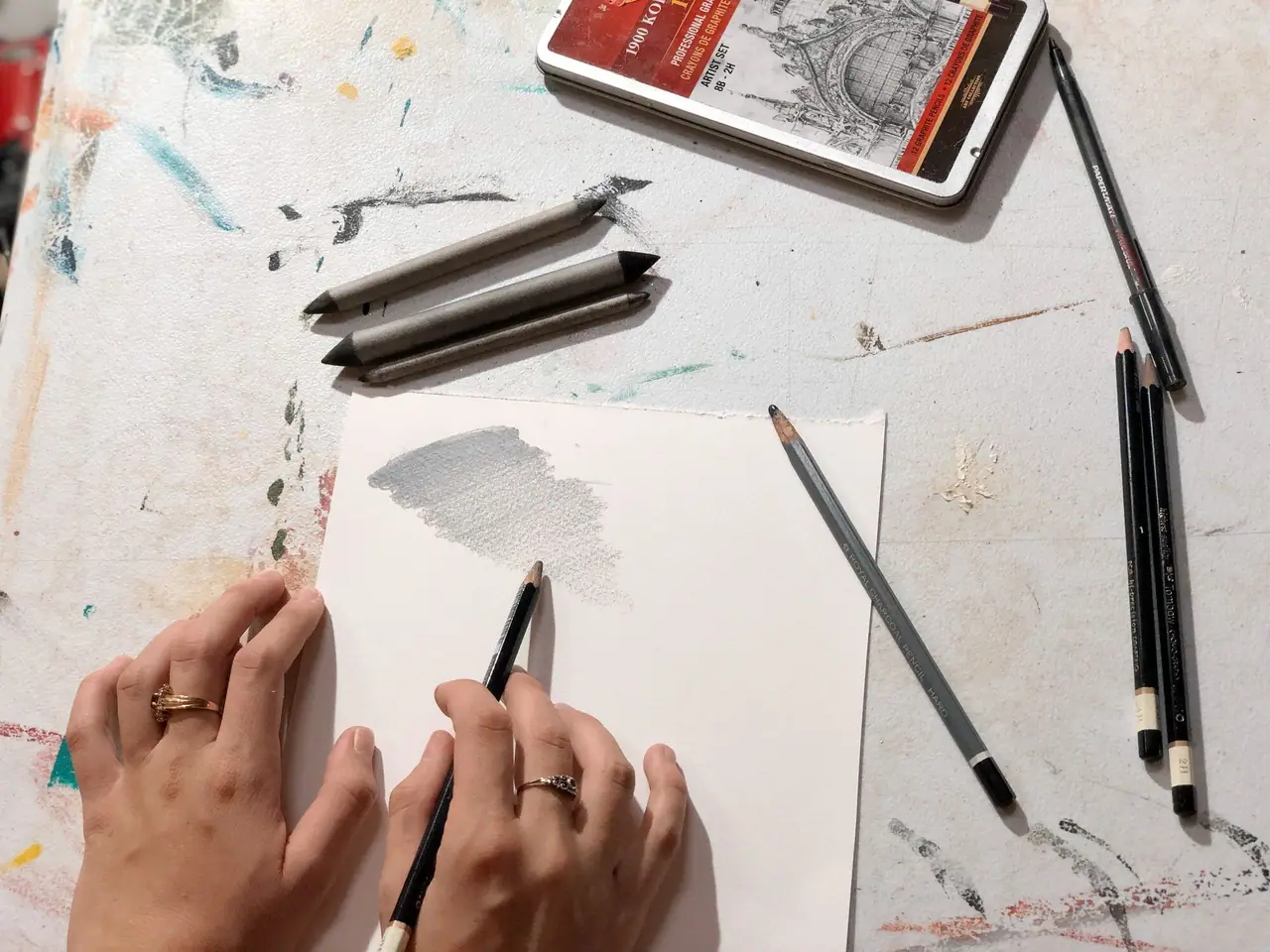 Hand shading a smooth pencil gradient from dark to light with charcoal and pencils