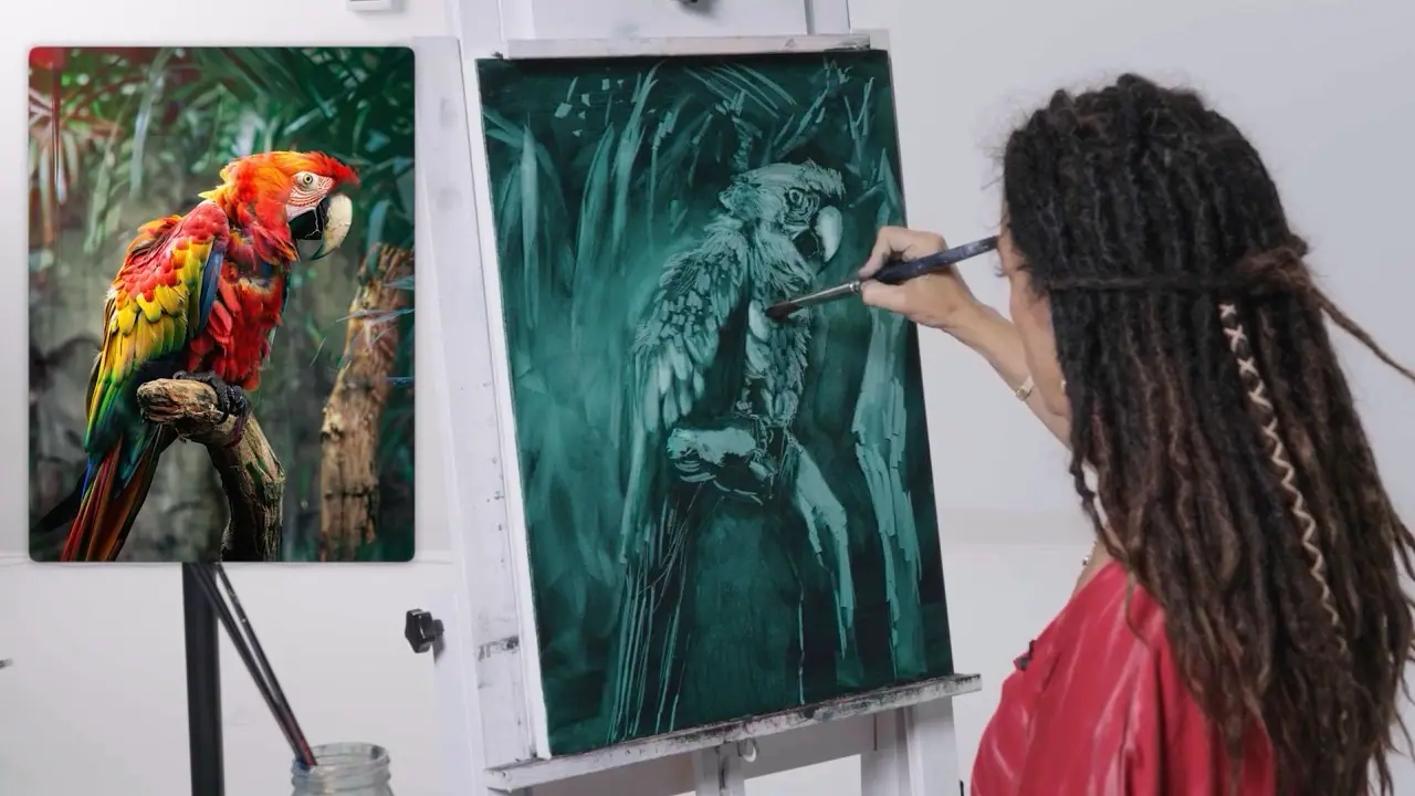 Artist in a red shirt painting a bird on a green canvas