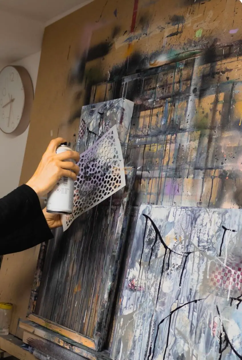 Spray paint applied over a stencil on an abstract canvas