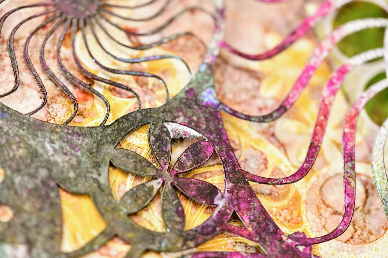 Stenciled metallic texture on a painting in green, yellow, and pink