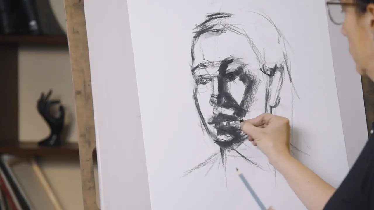 Hand drawing a pencil portrait with the eyes and nose placed along horizontal guidelines