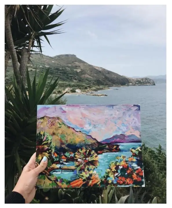 Sketchbook painting of an ocean and island view in soft blues and greens