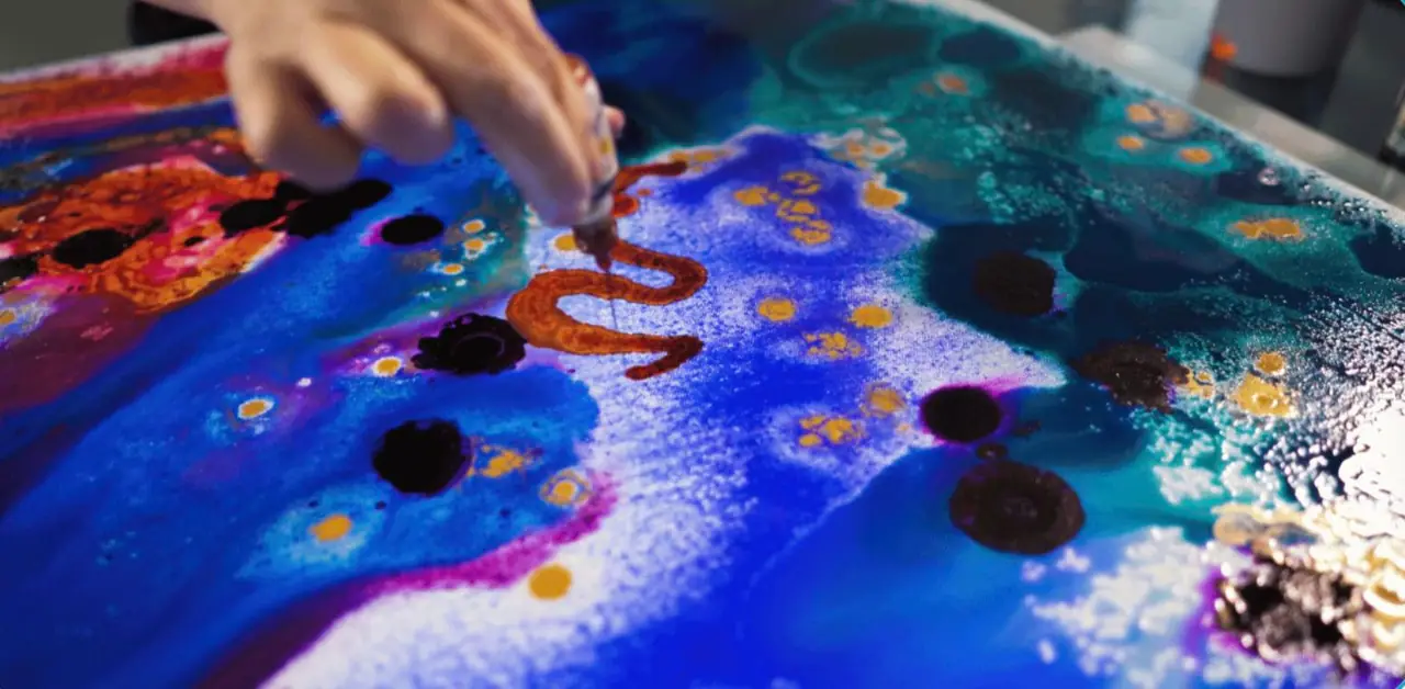 Abstract ink textures in blue, red, and green spreading across paper