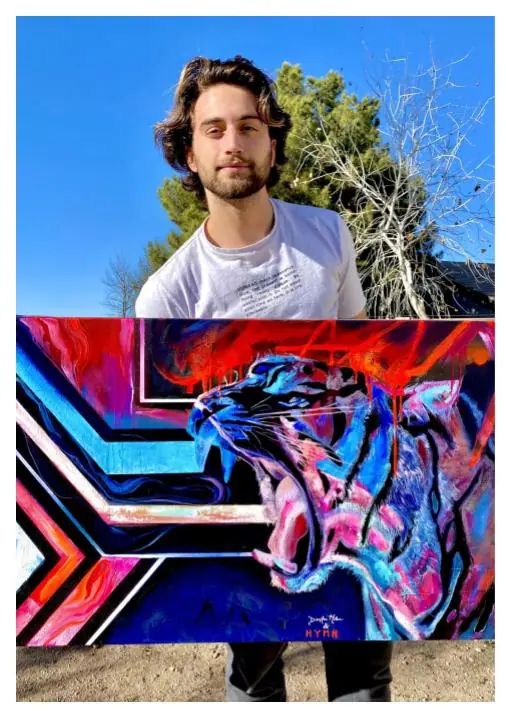 Beginning student standing beside a finished painting he created during the Mastery Program