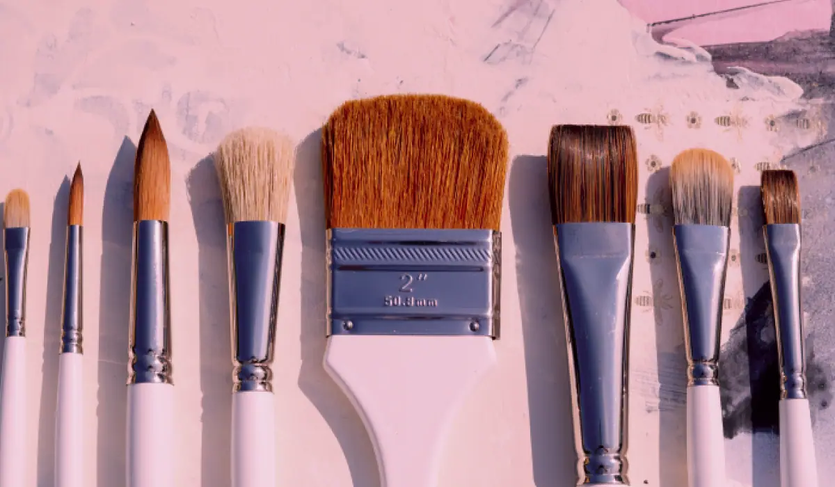 A fan of Fearless artist paint brushes with white handles and bristles in shades of brown
