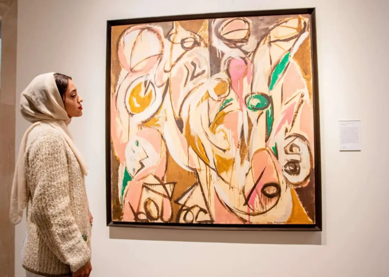Lee Krasner abstract painting Re Echo in yellow green pink and white with a viewer standing in front